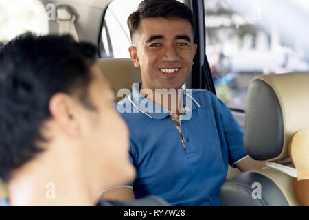 young handsome man looking at driver as passanger inside car Stock Photo
