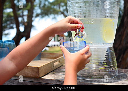 Kid pouring lemonade on the candy bar by the sea Stock Photo