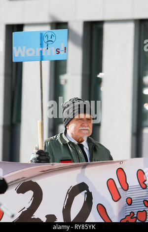 Wiesbaden, Germany. 12th Mar, 2019. A protester holds a poster with 'Worms' and a sad smiley written on it, referring to the recent killing of a woman by an asylum seeker in the city of Worms. The court case against the Iraqi asylum seeker Ali B. for the murder of Susanna F. from Mainz last year was opened in Wiesbaden. Several right wing organisations held a protest outside the court house against refugees in Germany and for harsher punishments for refugees. Credit: Michael Debets/Pacific Press/Alamy Live News Stock Photo