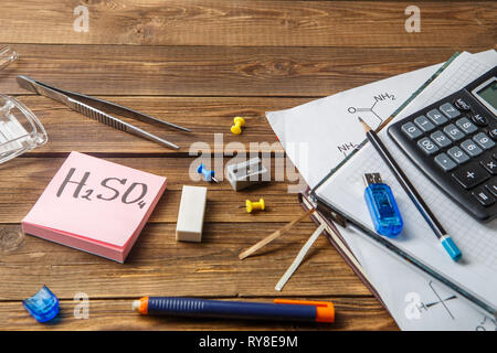 Chemical flasks, tweezers, keyboard, notebooks on a wooden table with copyspace. Stock Photo