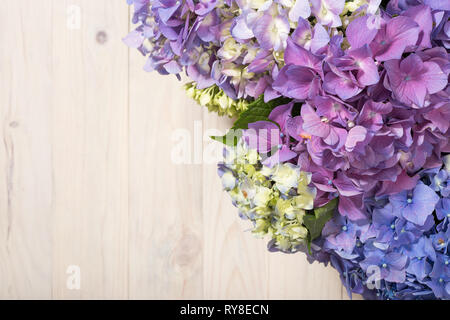 Hydrangea flowers on white wooden table. Top view. Floral border with copy space Stock Photo