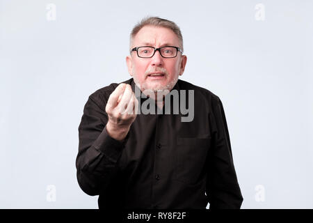 Senior man in black shirt showing italian gesture that means what do you want Stock Photo