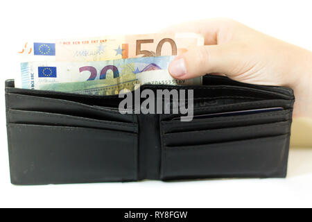 A wallet with euro banknotes and coins inside. Money to pay the bills and enjoy life Stock Photo