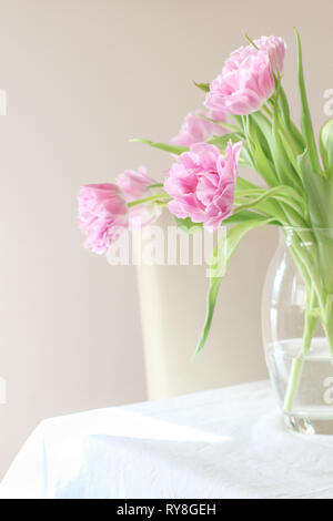 Pink tulips in a vase on a dinning table Stock Photo