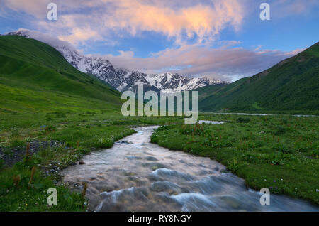 River in the mountains. Colorful sunset with beautiful clouds. Summer landscape. Main Caucasian ridge. Zemo Svaneti, Georgia Stock Photo