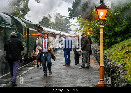 People heading for the races at Cheltenham arrive at Cheltenham racecourse on the Gloucestershire Warwickshire Steam Railway from Toddington, where a special heritage steam express train service is taking race goers to Cheltenham. Stock Photo