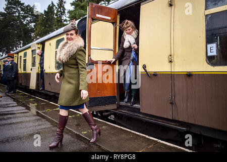 People heading for the races at Cheltenham exit their period carriage as they arrive at Cheltenham racecourse on the Gloucestershire Warwickshire Steam Railway from Toddington, where a special heritage steam express train service is taking race goers to Cheltenham. Stock Photo