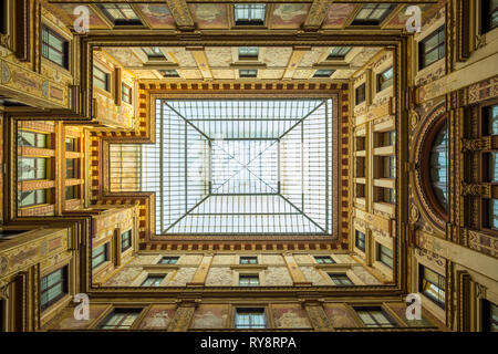 Looking up view of symmetrical covered glass skylight open air courtyard traditional Italian architecture of Galleria Sciarra in Rome, Italy Stock Photo