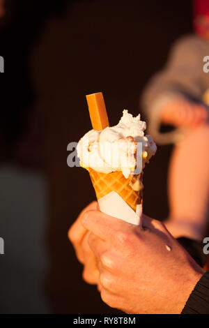 Person eating Gellato at seaside promenade Brighton /Hove  , famous location on promenade . Stock Photo