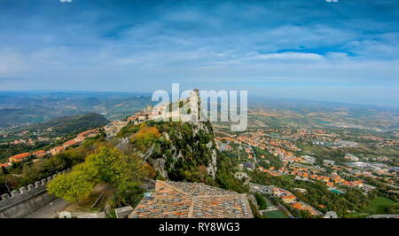 Closer look of the brick wall of the tower in San Marino Italy with the view of the houses and trees on the village below Stock Photo