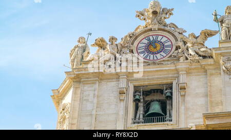 The big wall clock on the Basilica of Saint Peter in Vatican Rome Italy with the big bell below the big clock Stock Photo