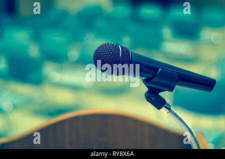 Microphone on the speech podium over the Abstract blurred photo of conference hall or seminar room background Stock Photo