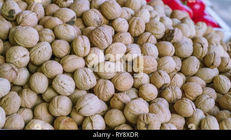 Lots of Greek walnut on dispay in the market stall for sale to the customers buying Stock Photo