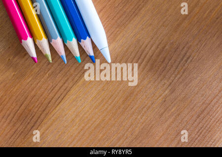 Apple Pencil 2015 1st generation for iPad Pro  and traditional coloured pencils on wooden table Stock Photo