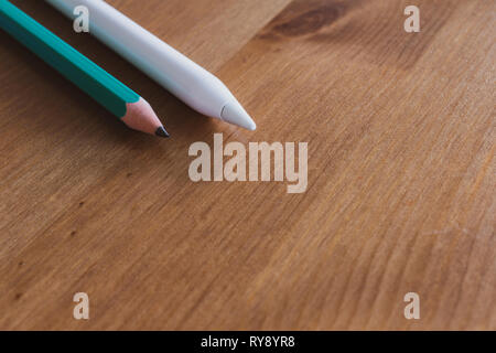 Apple Pencil 2015 1st generation for iPad Pro  and traditional pencil on wooden table Stock Photo