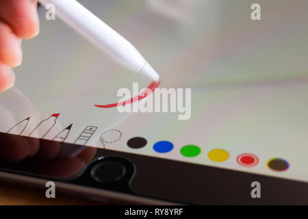 Drawing red line with Apple Pencil 2015 1st generation on iPad Pro Stock Photo