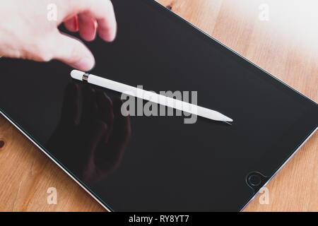 Apple Pencil 2015 1st generation on iPad Pro, hand reaching out for it Stock Photo