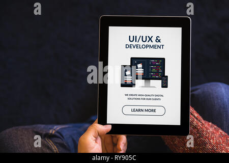 Hands holding digital tablet computer with UI/UX design and development concept on screen. All screen content is designed by me. Top view Stock Photo