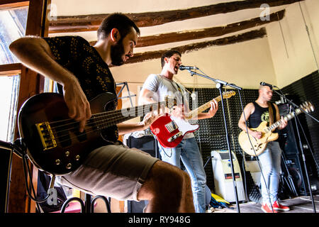 Male musicians singing and playing guitars in studio Stock Photo