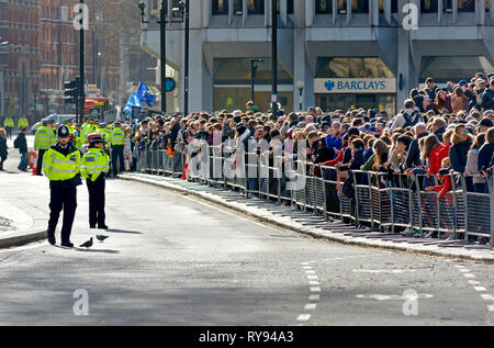 London, England, UK. Metropolitan police officers policing a crowd watching the Royal Family arriving at Westminster Abbey Stock Photo