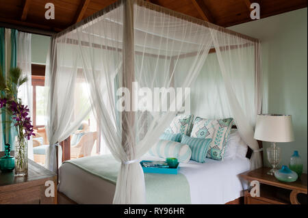 'Coastal bedroom with four poster bed in Tamarind Cove, Antigua' Stock Photo