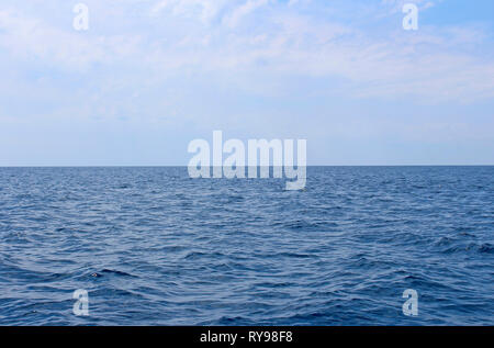 Seascape with sea horizon and almost clear deep blue sky. Background Stock Photo