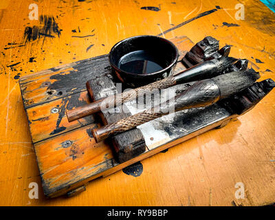 Close-up of Chinese Calligraphy brushes and ink on wooden brush shelf on writing table Stock Photo