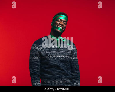 Man With Ribbon Happy african man with satin ribbon tied on his face against red ...
