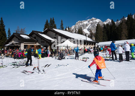 Skiing Italy - Skiers skiing on the ski slopes at Bar Montagnoli cafe, Madonna di Campiglio, Brenta Dolomites, northern Italy Europe Stock Photo