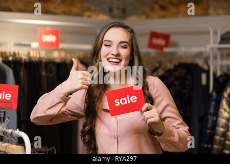 Young smiling brunette woman showing thumb up Stock Photo
