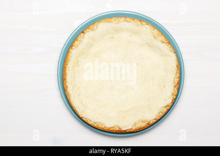 Whole cheesecake on a wooden white table. Top view. Stock Photo