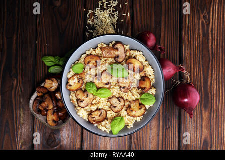 risotto with mushrooms, fresh herbs and parmesan cheese and basil Stock Photo