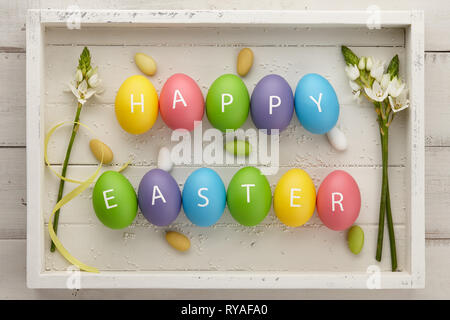 Colorful Easter eggs with letters on white planks Stock Photo