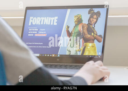 Child playing Fortnite game. Fortnite is popular online video game developed by Epic Games Stock Photo