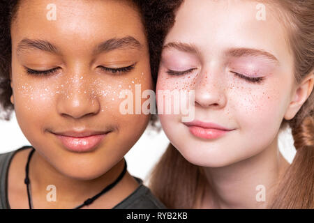 Dark-haired bronzed boy posing with pale long-haired girl Stock Photo