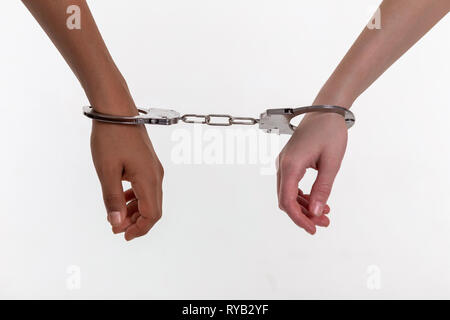 Hands of little kids being closed in rough metal handcuffs Stock Photo