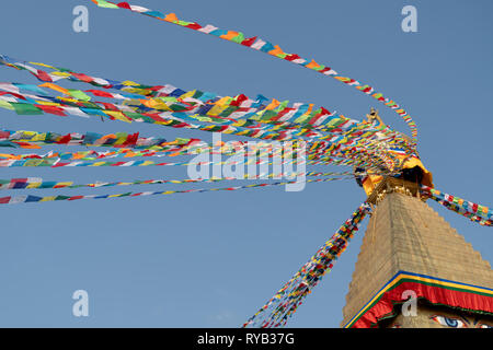 Low angle view of colorful prayer flags hanging on temple against clear blue sky during sunny day Stock Photo