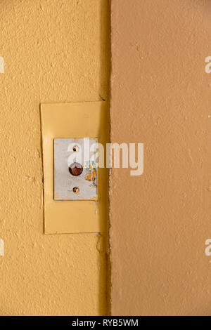 Old elevator call button with grungy pattern in a soviet building in post-soviet Riga, Latvia Stock Photo