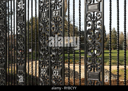 Old ornamental black cast iron metal entry gates to Oxford University Parks from Parks Road in winter / spring showing dates 1853 and 2003 Stock Photo