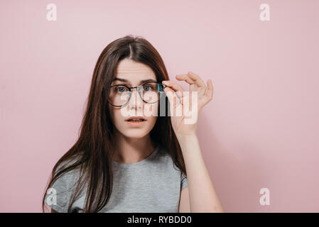 Close up portrait of young woman frowning puzzled teacher looking serious, has  attentive gaze at something. A beautiful female woman in eyewear looking Stock Photo