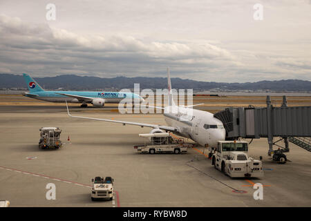 Osaka, Japan - February 8, 2019: Japan Airlines flight takes on passengers as Korean Air taxis at Kansai International Airport, the region's largest a Stock Photo