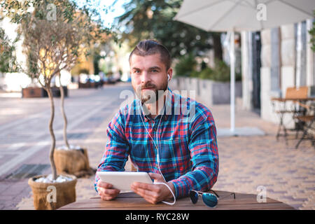 Handsome hipster guy working on digital tablet. Stock Photo