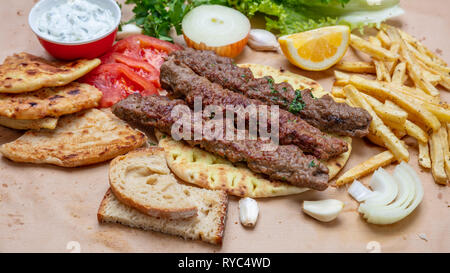 Kebab, traditional turkish, greek meat food on pita bread, tzatziki sauce and potatoes Stock Photo