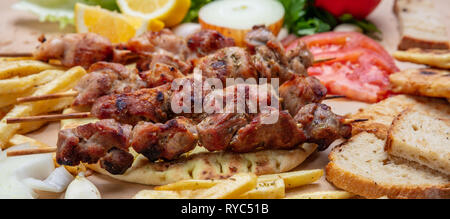 Souvlaki, meat skewers, traditional greek turkish meat food on pita bread,vegetables and potatoes, banner Stock Photo