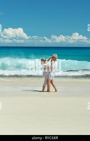 Portrait of elderly couple dancing on tropical beach Stock Photo