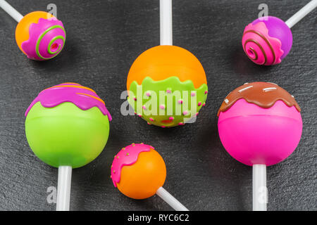 Colorful plastic candies and lollipops over stone background Stock Photo