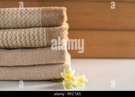 Stack of beige towels on wooden background. Stock Photo