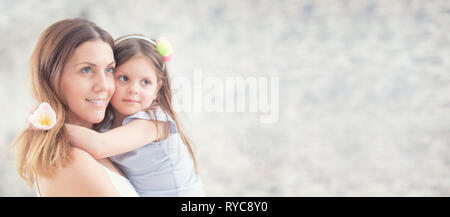 Happy mother's day concept. Portrait of loving mother with her daughter on her hands. Panoramic banner with copy space. Stock Photo