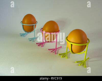 Brown eggs of light color prepare for the holiday Easter against the background from a white rope and dark branches of a tree with bright multi Stock Photo