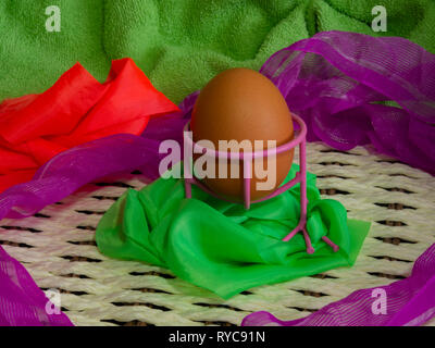 Brown eggs of light color prepare for the holiday Easter against the background from a white rope and dark branches of a tree with bright multi Stock Photo